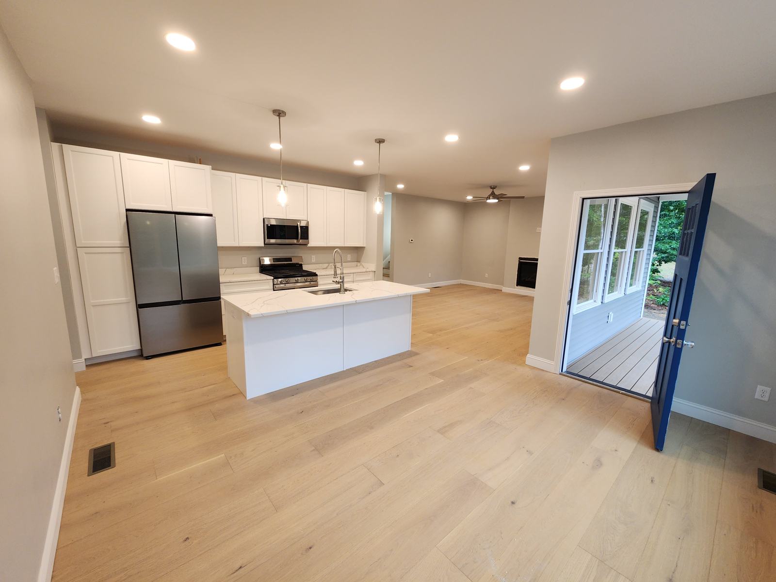 Kitchen and living area with open front door